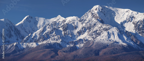 Snow-capped mountain peaks, contrasting morning light, pano