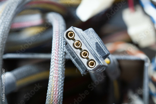 Very dirty wires, connectors and plugs in the computer. Old multi-colored wires in a braided wrapper. Stranded electrical wire in electronic equipment. Service workshop for electronics repair.