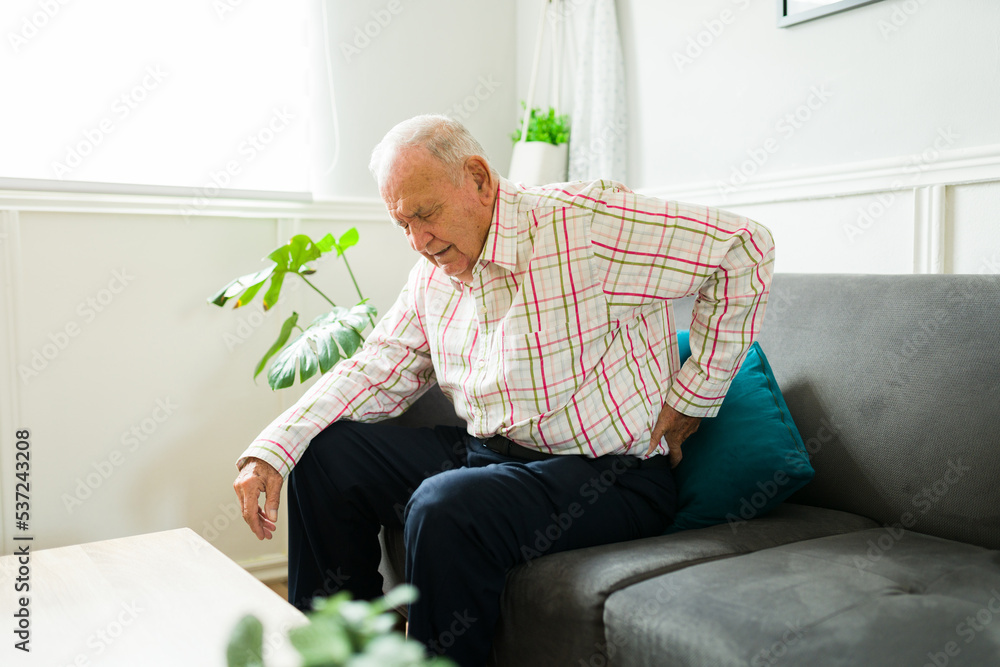 Injured old man feeling back pain while trying to get up Injured old man feeling back pain while trying to get up