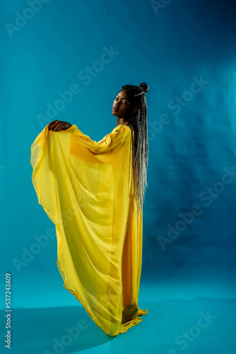 a girl in a yellow dress on a blue background