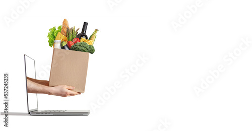 hands of a courier with a package of groceries in a laptop