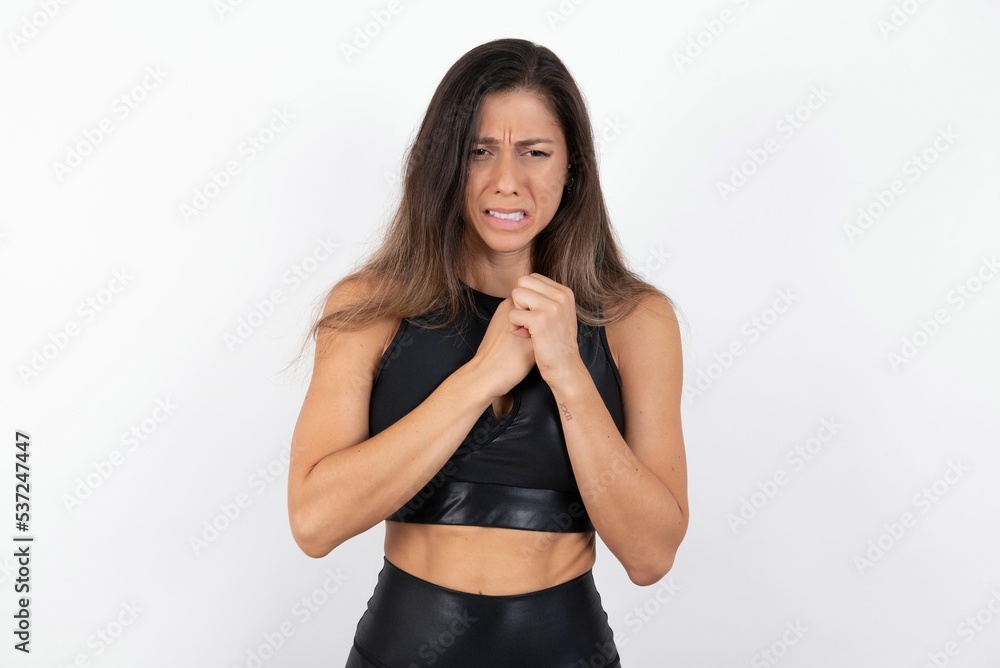 Sad young beautiful woman wearing sportswear over white background desperate and depressed with tears on her eyes suffering pain and depression in sadness facial expression and emotion concept Sad young beautiful woman wearing sportswear over white background desperate and depressed with tears on her eyes suffering pain and depression in sadness facial expression and emotion concept