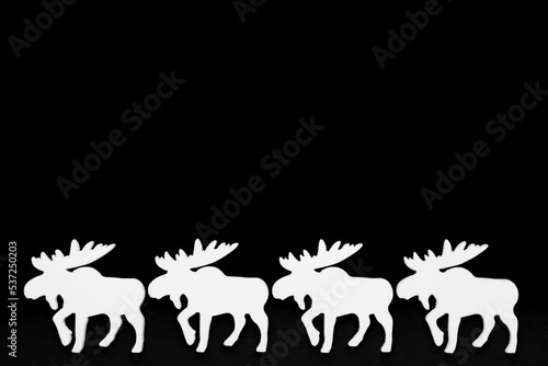 White wooden reindeer on a black background  christmas silhouette. Top view  copy space.