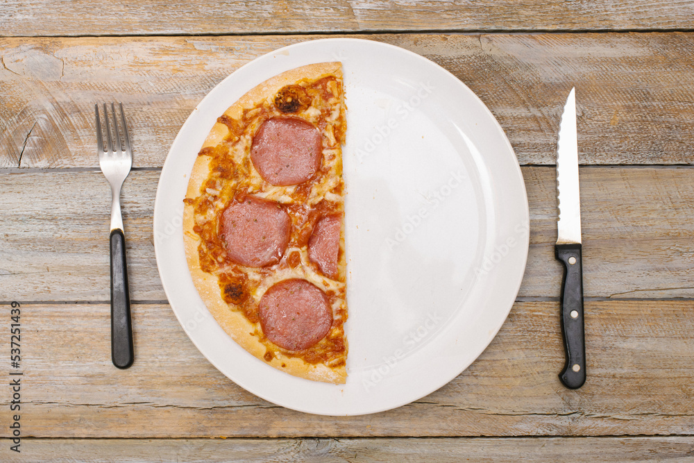 One half - Pizza pieces series as illustration of division in maths on wood table
