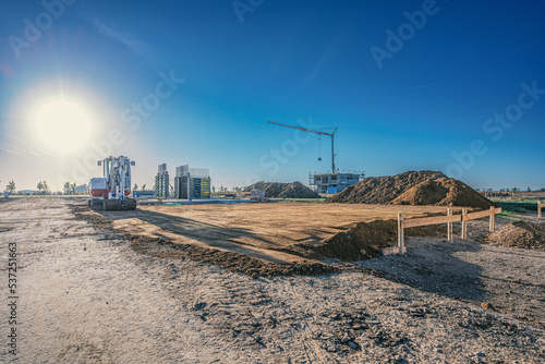 Minnibagger auf Baustelle mit Baukran