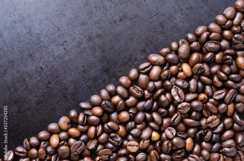 Coffee beans on dark background  diagonal order aligned close-up still life with copy space for text