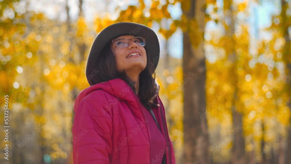 Portrait of cheerful Indian female wearing cap and looking at warm fall colors of autumn trees at Sissu, Himachal Pradesh, India. Attractive woman in the park at fall on a sunny day. Autumn background Portrait of cheerful Indian female wearing cap and looking at warm fall colors of autumn trees at Sissu, Himachal Pradesh, India. Attractive woman in the park at fall on a sunny day. Autumn background