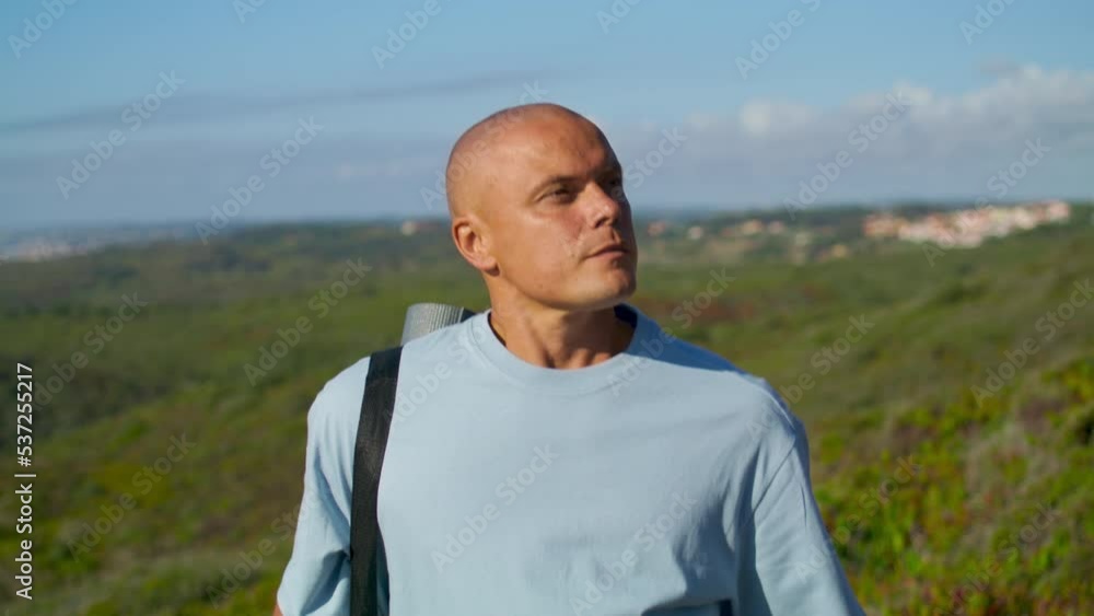 Athletic man walking outdoors with yoga mat. Focused tourist going natural park Athletic man walking outdoors with yoga mat. Focused tourist going natural park