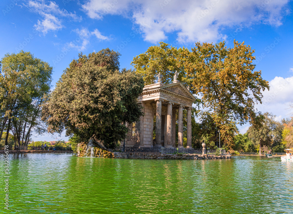 Temple of Asclepius situated in the middle of the small island on the artificial lake in Villa Borghese gardens , Rome, Italy. The greek inscription «Ασκληπιωι Σωτηρι» meaning 'Asclepius Savior'. Temple of Asclepius situated in the middle of the small island on the artificial lake in Villa Borghese gardens , Rome, Italy. The greek inscription «Ασκληπιωι Σωτηρι» meaning 'Asclepius Savior'.