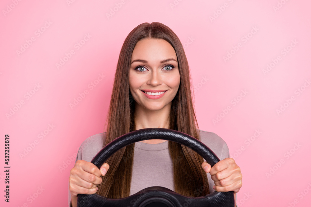Photo of cheerful adorable lady arms hold wheel steering beaming smile isolated on pink color background Photo of cheerful adorable lady arms hold wheel steering beaming smile isolated on pink color background