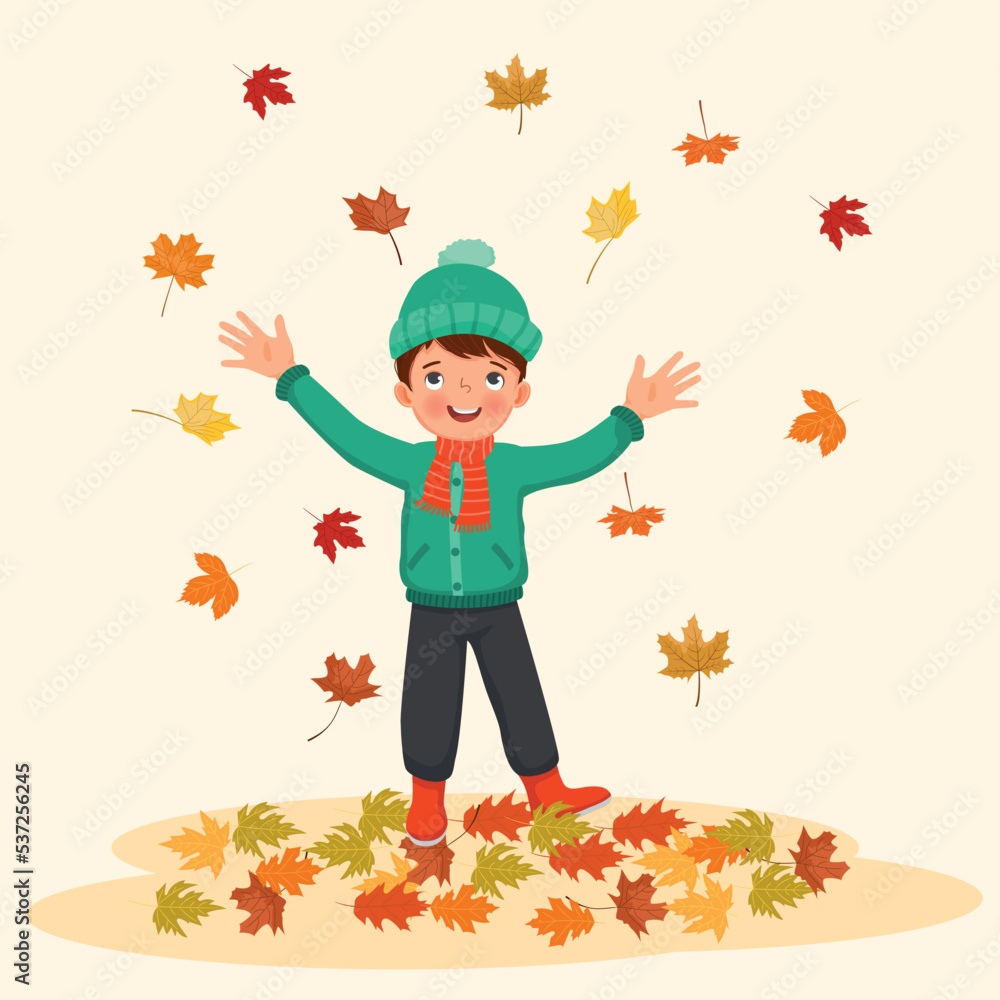 happy little boy playing outside with fallen leaves in autumn happy little boy playing outside with fallen leaves in autumn
