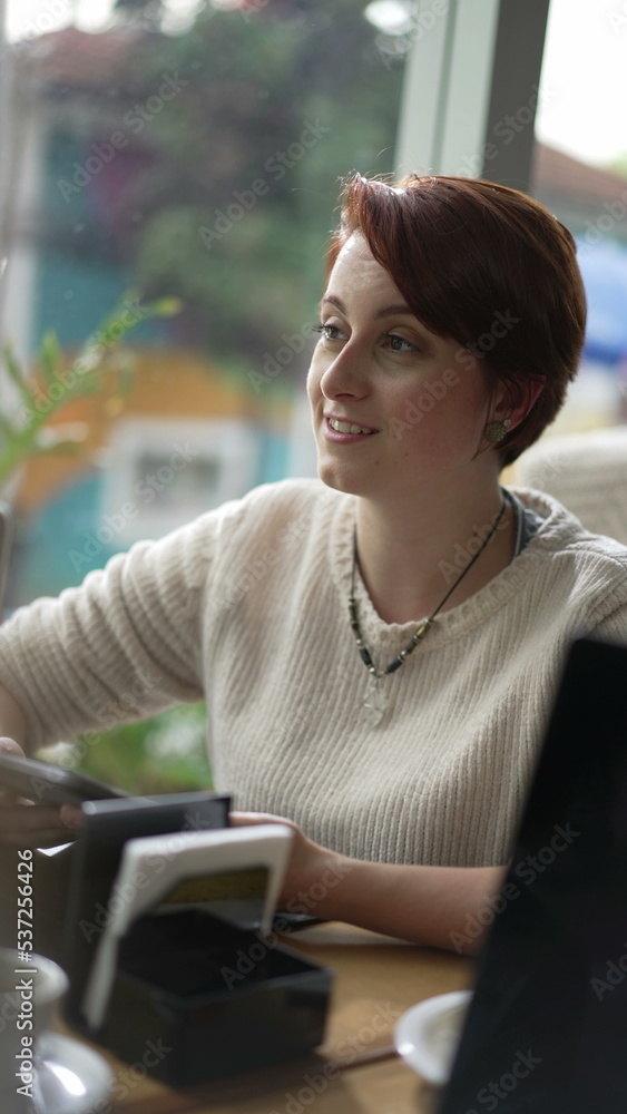 Red hair young woman talking at coffee shop. Candid girl in conversation smiling in interaction with friend at cafe restaurant Vertical video SS Red hair young woman talking at coffee shop. Candid girl in conversation smiling in interaction with friend at cafe restaurant Vertical video SS