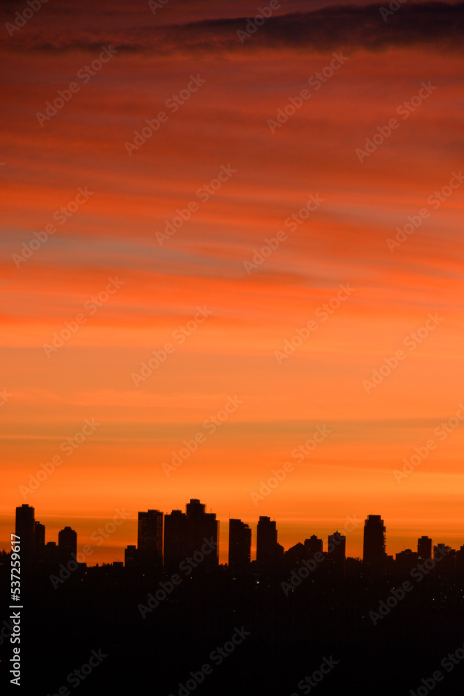 silhouette of residential buildings on sunset sky background