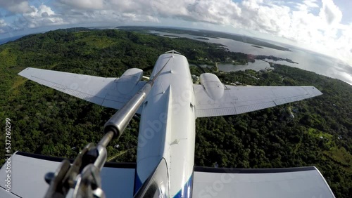 External perspective of twin engine plane flying over ocean photo