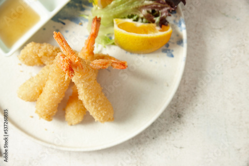 ebi tempura with lemon on a white plate photo