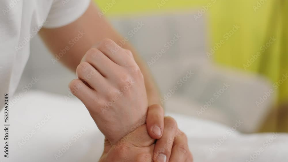 At spa salon the masseur closeup to the camera taking details massage well the hands of his client while the client are laying on the massage table At spa salon the masseur closeup to the camera taking details massage well the hands of his client while the client are laying on the massage table