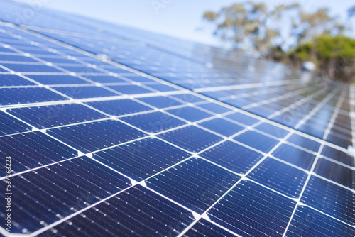 Rows of blue solar panels up to sky on roof of home
