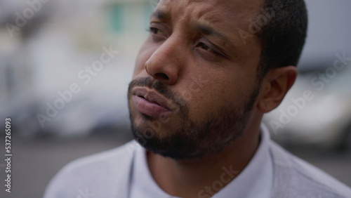 One anxious young African American man in distress closeup face. Portrait of a black person with worried preoccupied emotion