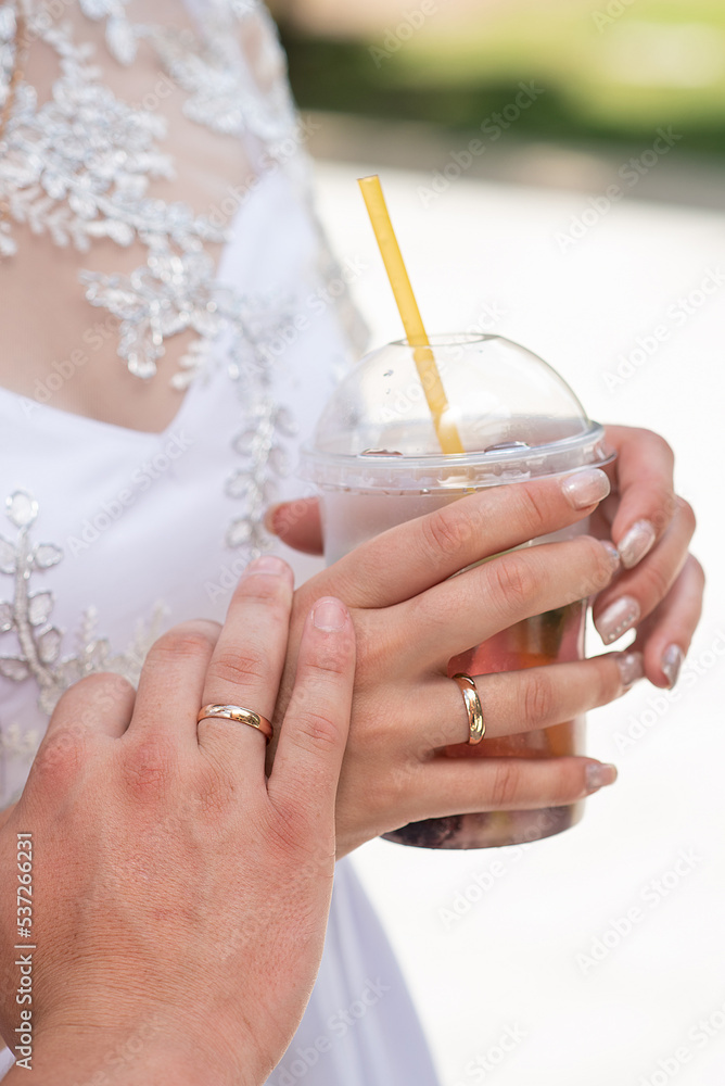 newlyweds with cocktails in their hands. close-up of the hand and ring. summer drink newlyweds with cocktails in their hands. close-up of the hand and ring. summer drink