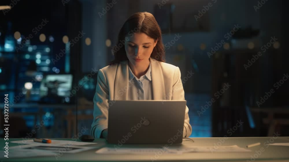 Beautiful Female Working on Laptop Computer in a Company Office at Night. Young Secretary Analyzing Reports. Marketing Assistant Developing a Marketing Strategy for a Client. Beautiful Female Working on Laptop Computer in a Company Office at Night. Young Secretary Analyzing Reports. Marketing Assistant Developing a Marketing Strategy for a Client.