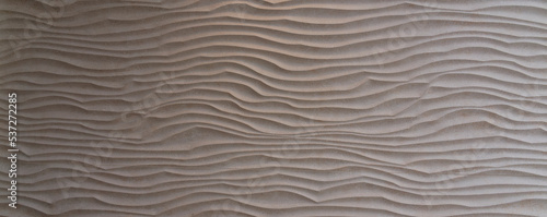 Stone waves, beautiful three-dimensional wave structure worked in beige colored stone slab. Copy space for your design or product. Web banner.