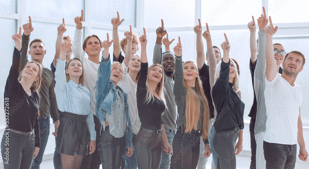 group of successful young people pointing up