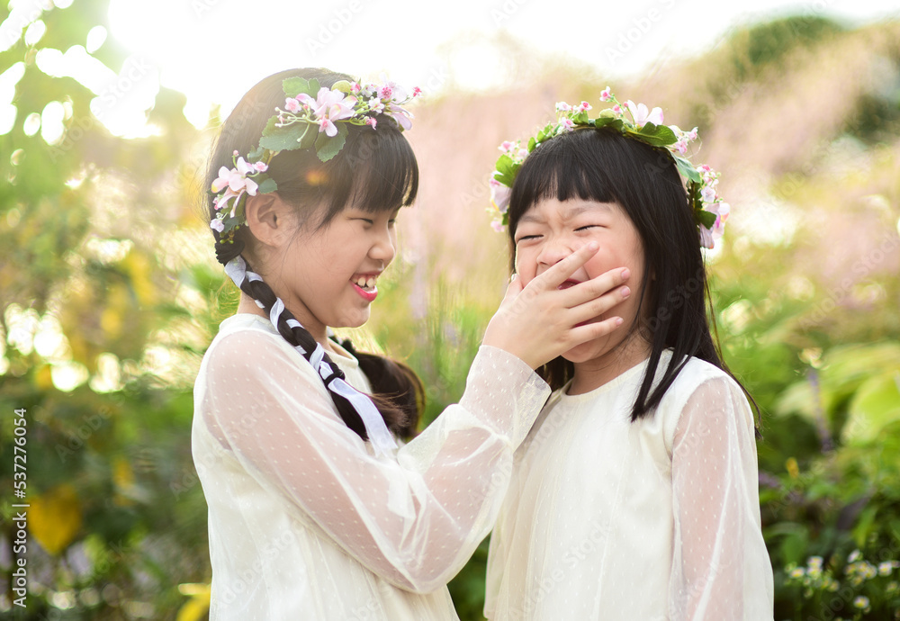 Fototapeta premium Two Asian sister in garden