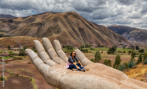 A woman at the Mirador de Cielo Punku viewpoint in Huaro, Cusco, Peru. This viewpoint consists of two hands reaching down into the valley. photo