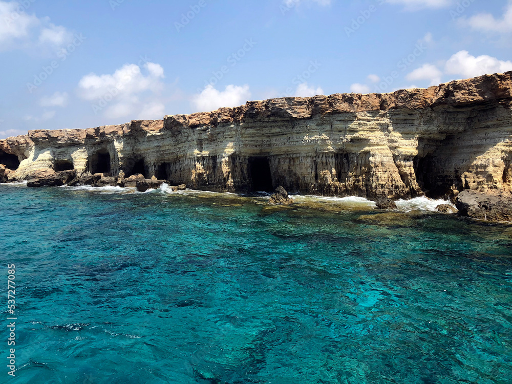 White cliffs of Cyprus. Scenic sea caves near Paphos. Beautiful Cyprus landscape. Cypriot coast view from water. Very calming and relaxing seascape. Turquoise Mediterranean sea and white rocks