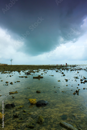 Overcast clouds over a rocky beach in Jepara, Central Java, Indonesia