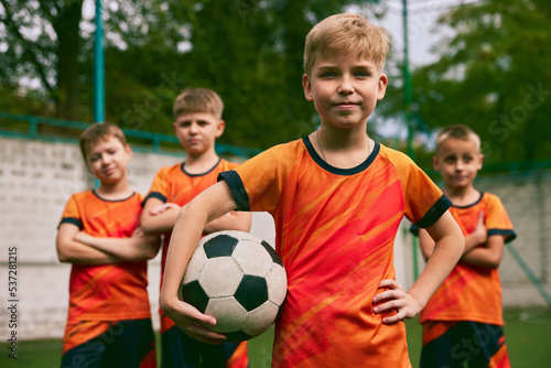 Future football champions. Little boys, kids in sports uniform posing with ball at soccer school stadium. Concept of sport, studying, achievements, success