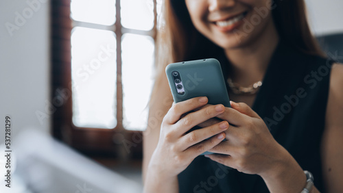 young businesswoman looking at financial information from a mobile phone, she is checking company financial documents, she is a female executive of a startup company. Concept of financial management.