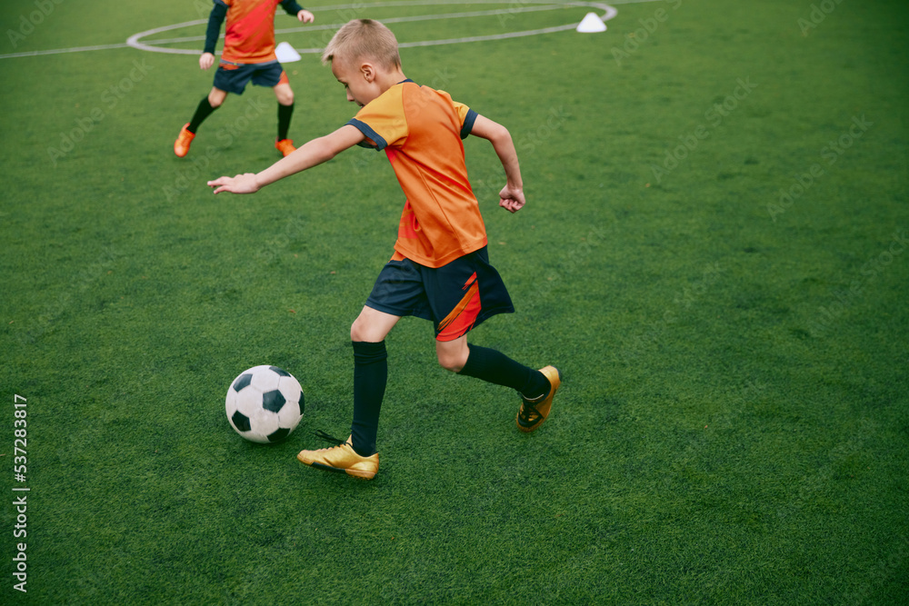 Workout. Junior soccer team playing football at sports stadium, outdoors. Concept of sport, competition, studying and achievements