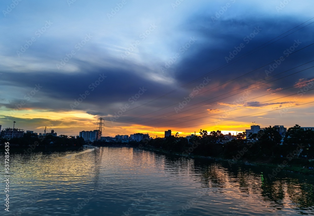 Sunset at the coast of the lake. Nature landscape. Nature in Bangladesh. reflection, blue sky, and yellow sunlight. landscape during sunset. Sunset at the coast of the lake. Nature landscape. Nature in Bangladesh. reflection, blue sky, and yellow sunlight. landscape during sunset.