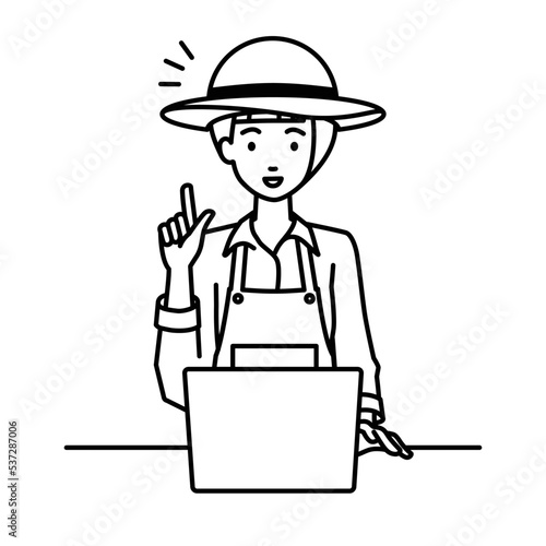 デスクで座ってPCを開いて何かひらめいた農家の女性