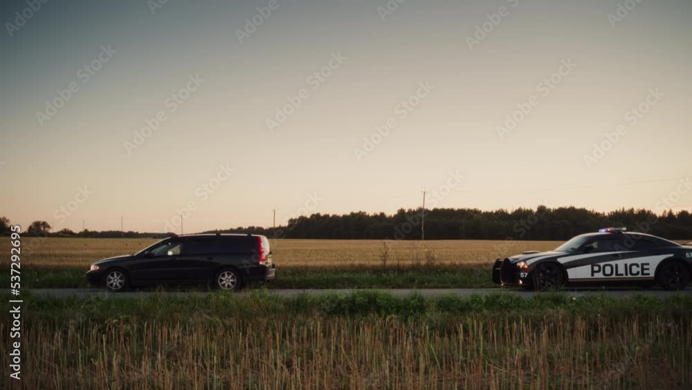 Highway Traffic Patrol Car Pulls over Vehicle Check on Empty Road. Police Officer Comes out of Car and Person for License and Registration, writes a Ticket. Cinematic Wide Angle Side View Shot Highway Traffic Patrol Car Pulls over Vehicle Check on Empty Road. Police Officer Comes out of Car and Person for License and Registration, writes a Ticket. Cinematic Wide Angle Side View Shot