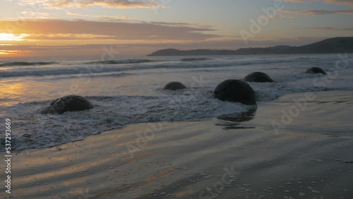 Sunrise on the Moeraki Boulders on the beach, in New Zealand