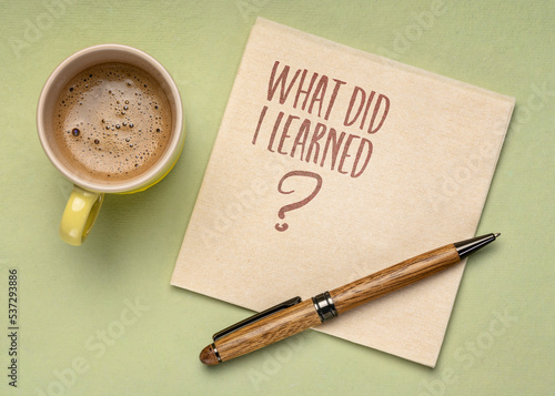 What did I learned? Handwriting on a napkin with a cup of coffee. Learning, experience and education concept.