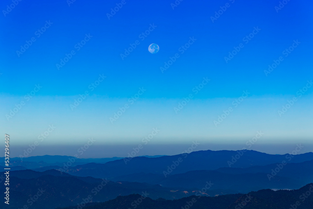 Moon and day in bright clouds before sunset. Moon in the blue sky. Moon and day with mountain. Day moon in summer time. Mountain and moon day with blue sky. Moon and day in bright clouds before sunset. Moon in the blue sky. Moon and day with mountain. Day moon in summer time. Mountain and moon day with blue sky.