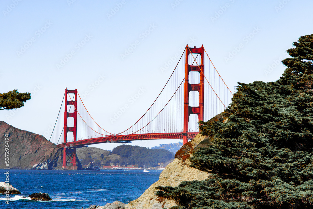 Fototapeta premium Famous Golden Gate bridge in San Francisco with a clear blue sky and wavy sea