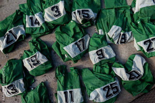 Photography Stockholm, Sweden Numbered green sport team jerseys lay on the ground for use in a grou pactivity