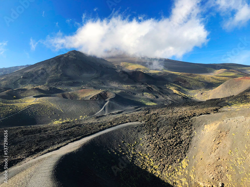 Incredible scenery of volcano Etna in Sicily island. Famous Sicilian landmark  Italian mount paysage. Mount Etna panoramic view with craters and peaks on a sunny day. Italian scenery. Volcanic lava