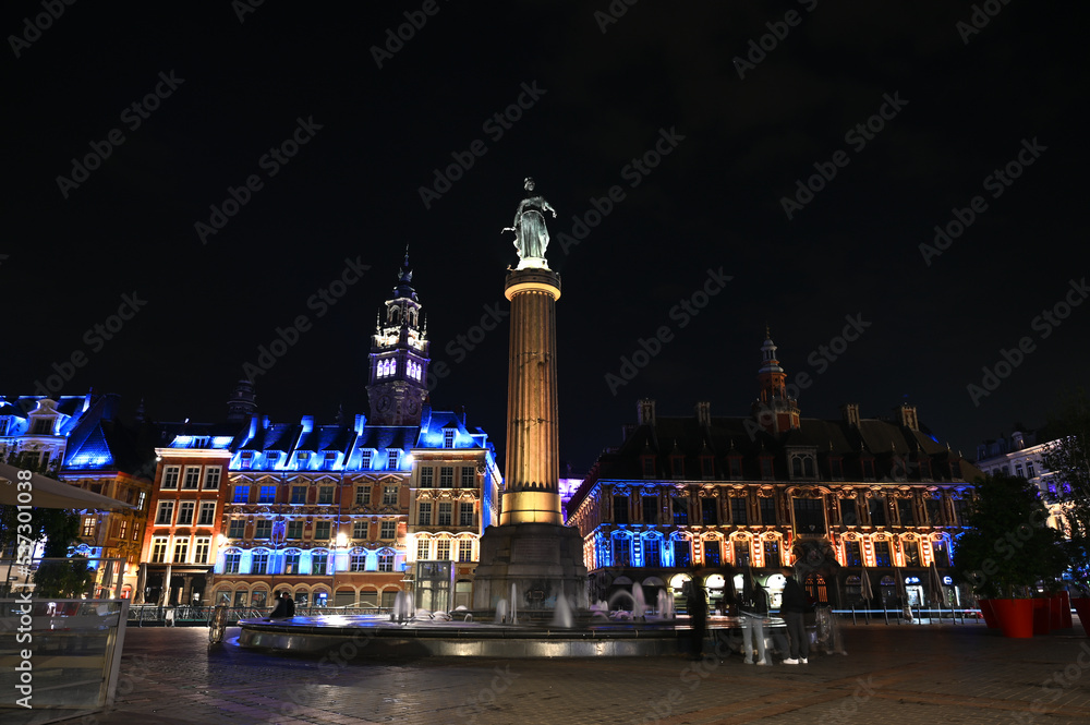 Obraz premium Lille, France: Main square or Grand Place at night. Historical buildings in city centre. Fountain, column and memorial. 