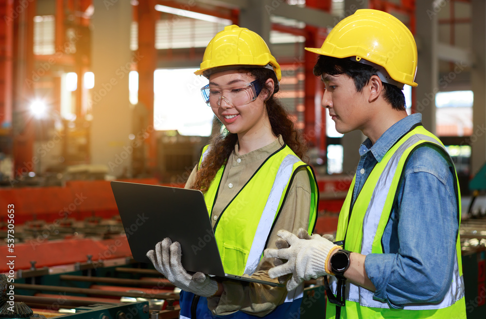 Team of Asian male and female engineers using laptops. Check machine maintenance Team of Asian male and female engineers using laptops. Check machine maintenance