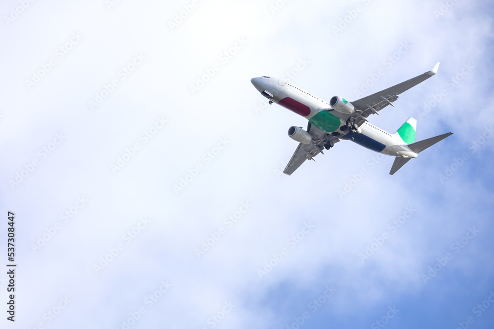 Airplane in blue sky with light clouds over the house Airplane in blue sky with light clouds over the house