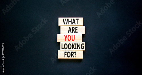 What are you looking for symbol. Concept words What are you looking for on wooden blocks. Beautiful black table black background. Business what are you looking for concept. Copy space.