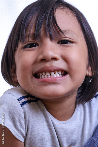 close up of a little girl with a smile showing his theet photo