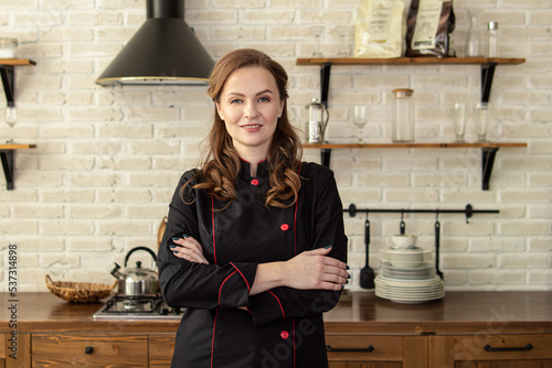 Tableau sur toile Woman in chef's uniform in the kitchen