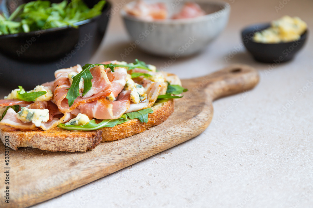 Toast with bacon, fresh arugula and blue cheese. Toast with bacon, fresh arugula and blue cheese.