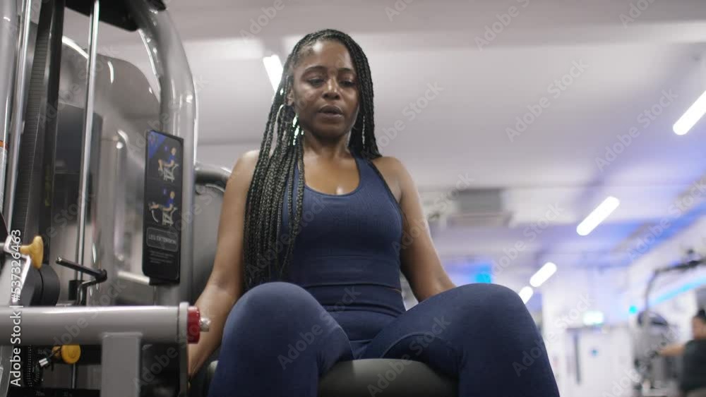 Attractive fit woman working out her legs on knee extension machine Attractive fit woman working out her legs on knee extension machine